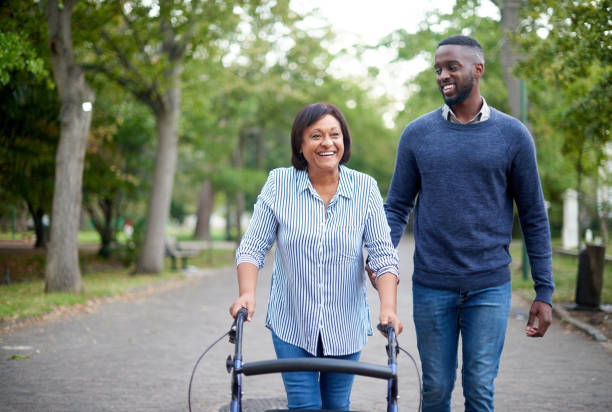 Woman with walker receiving mobility support from companion