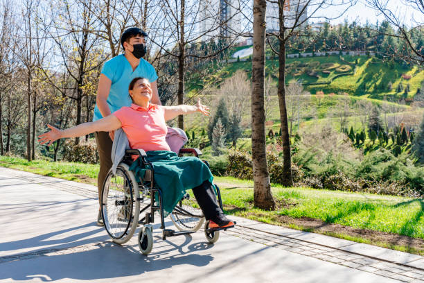 Senior in wheelchair enjoying a park outing with caregiver