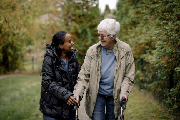 Caregiver and senior walking outdoors together