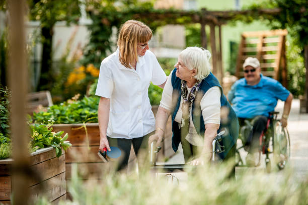 Caregiver providing outdoor walking support to client