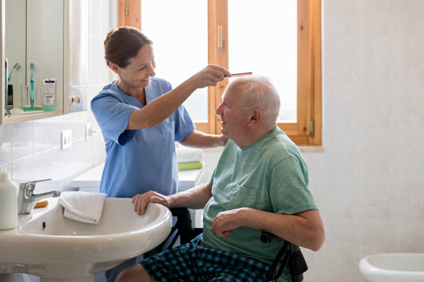 Caregiver combing elderly client hair